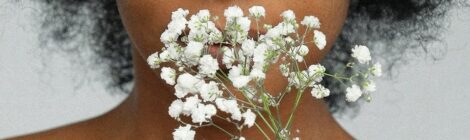 primo piano di ragazza che annusa un fiore bianco