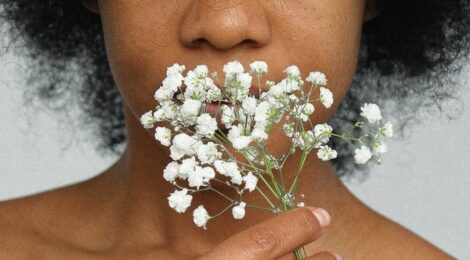 primo piano di ragazza che annusa un fiore bianco